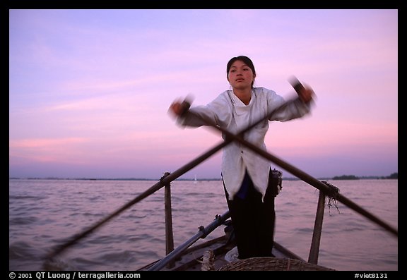 Woman using the X-shaped  paddle characteristic of the Delta. Can Tho, Vietnam (color)