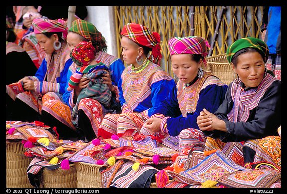 Women sell the colorful garnments after which the Flower Hmong are named. Bac Ha, Vietnam (color)