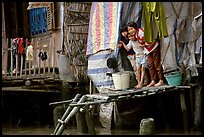 Children peering from their waterfront house. Can Tho, Vietnam (color)